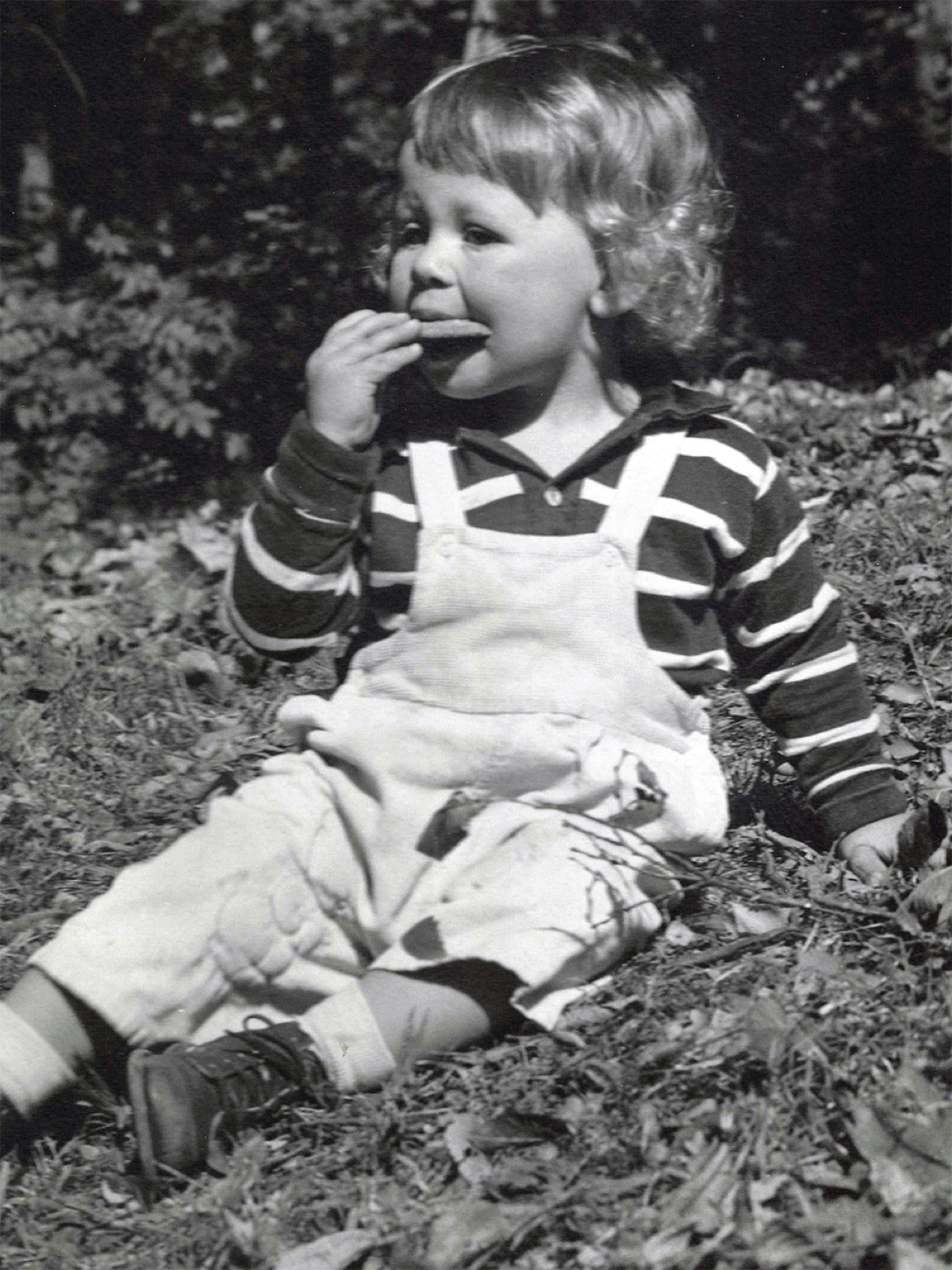 Allen as a toddler, eating a cookie in the yard