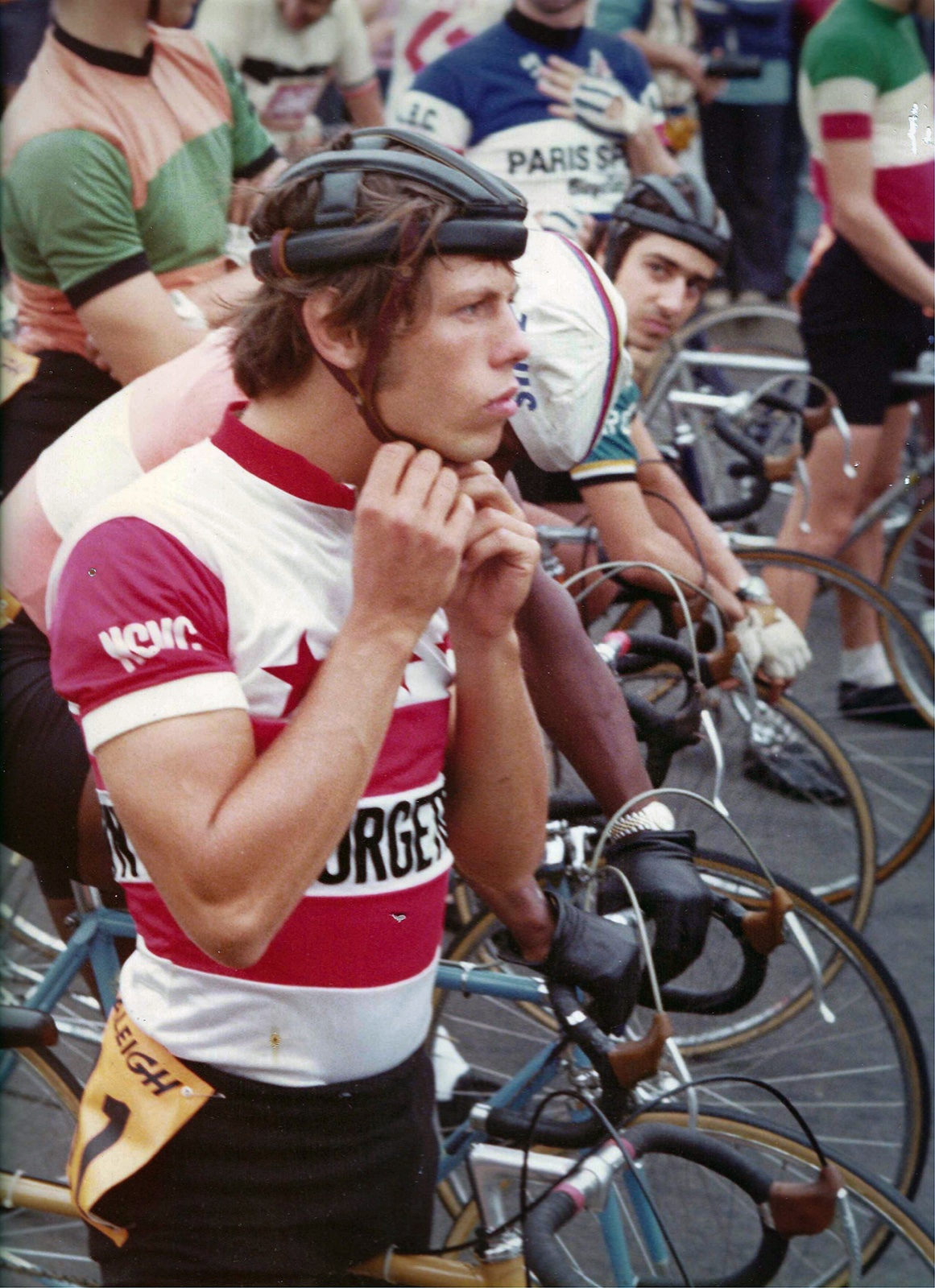 Allen at the start line, buckling his helmet, in his NCVC jersey