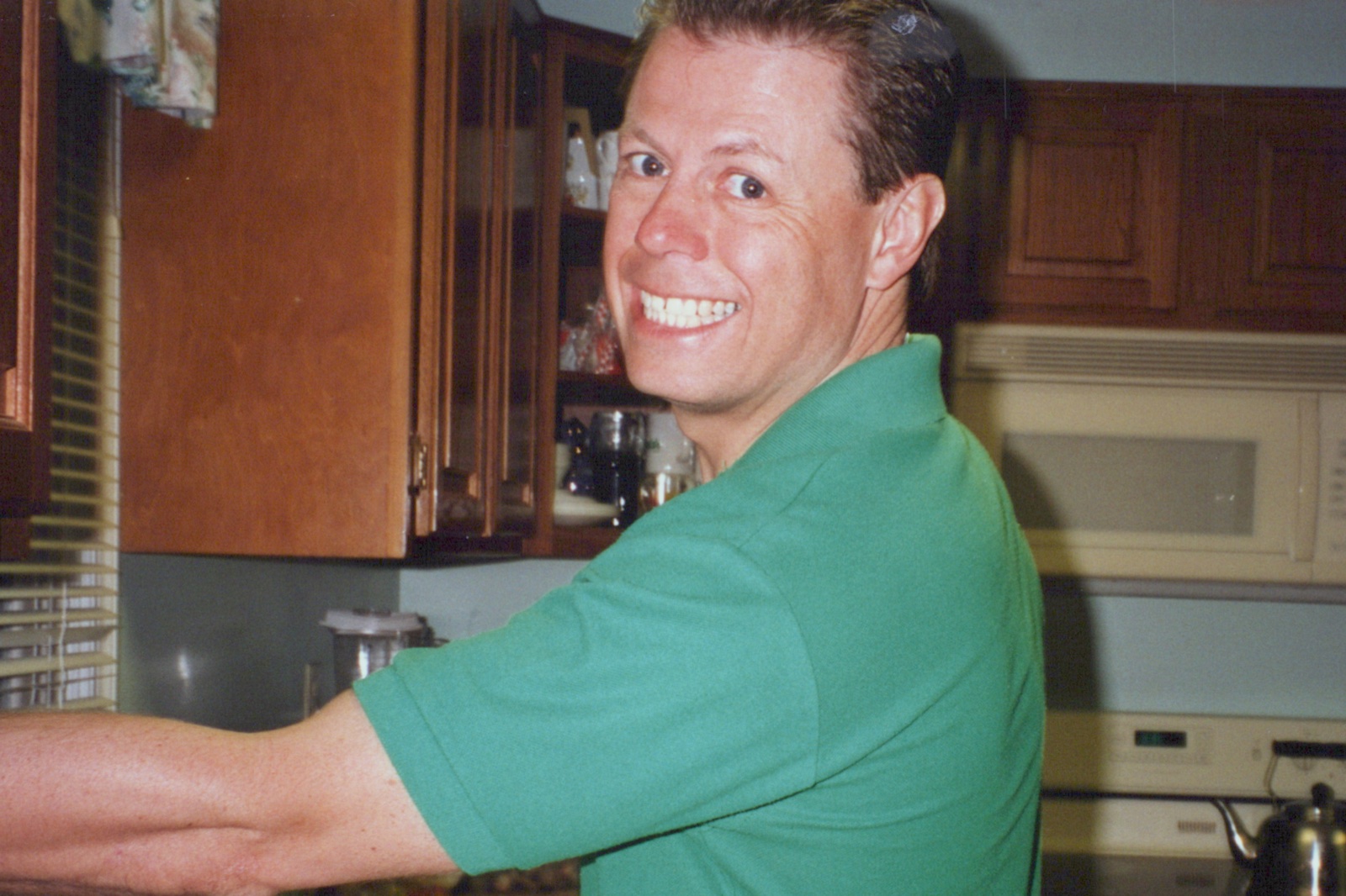Allen flashing his big grin over his shoulder in the kitchen